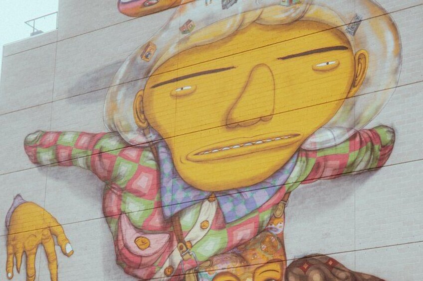 Une fresque colorée représentant un personnage portant une chemise à carreaux et un chapeau. 3