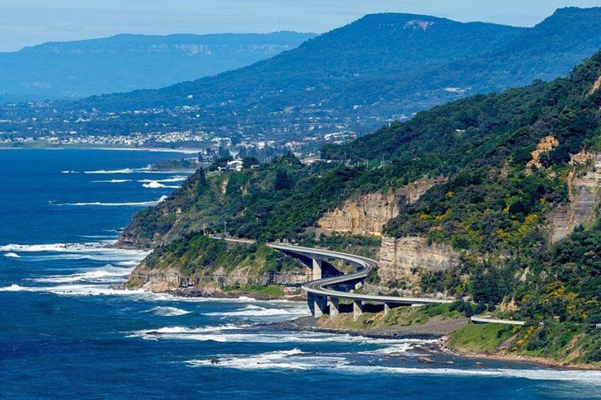 A coastal highway curving along a cliffside, overlooking the ocean. 1