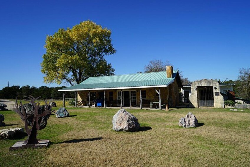 A building with a green roof, surrounded by rocks and a tree. 3