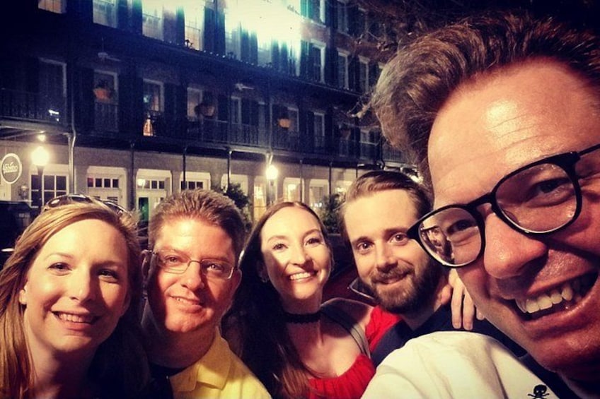A group of people taking a selfie in an urban setting with buildings in the background. 3