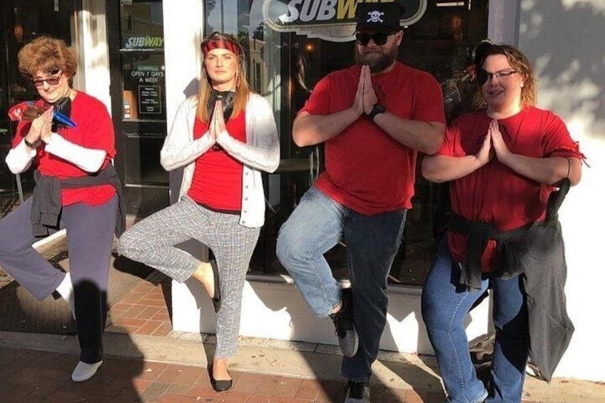 Four people in front of a Subway restaurant, performing a synchronized dance. 2