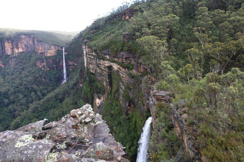 A canyon with waterfalls and dense forest. 1