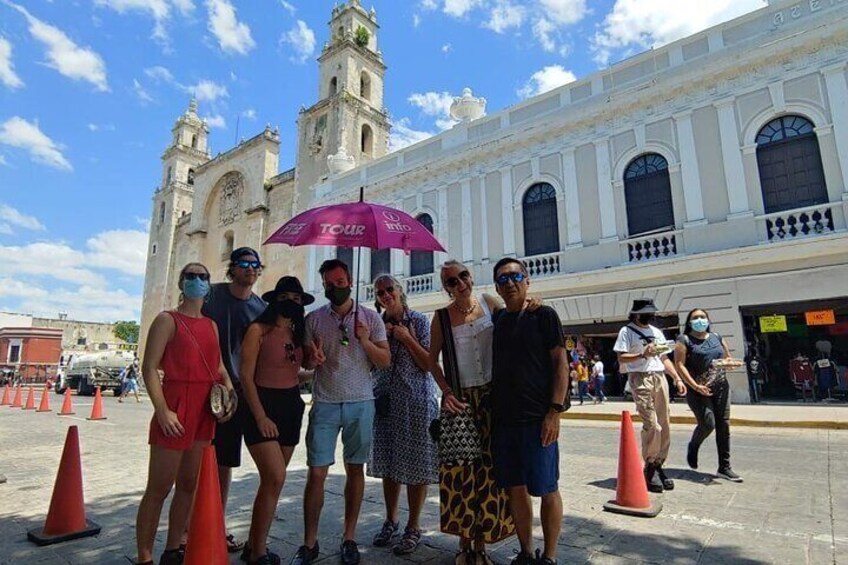 A group of people standing in front of a historic building with a clock tower. 4