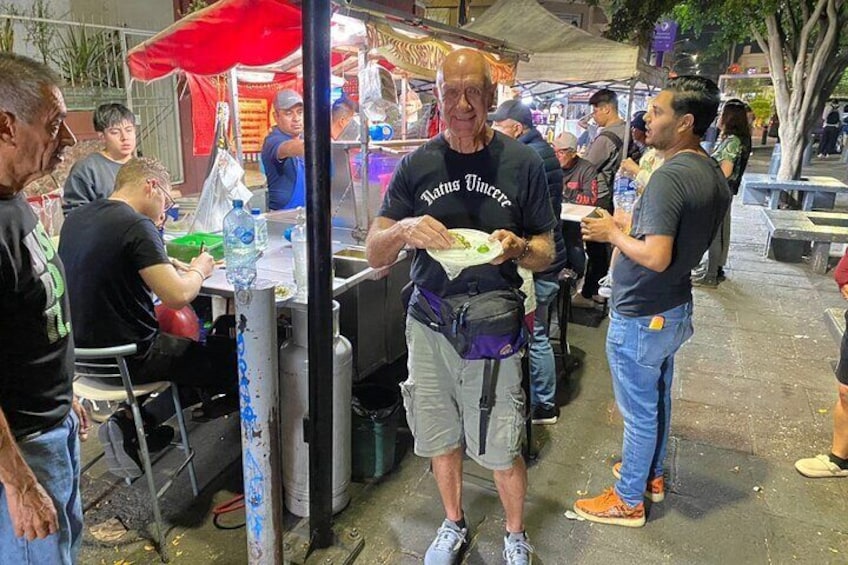 People eating at an outdoor food stall. 3