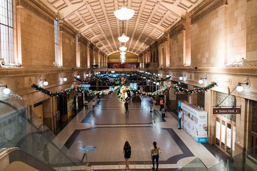 A spacious indoor area with high ceilings, large windows, and decorative garlands. 5