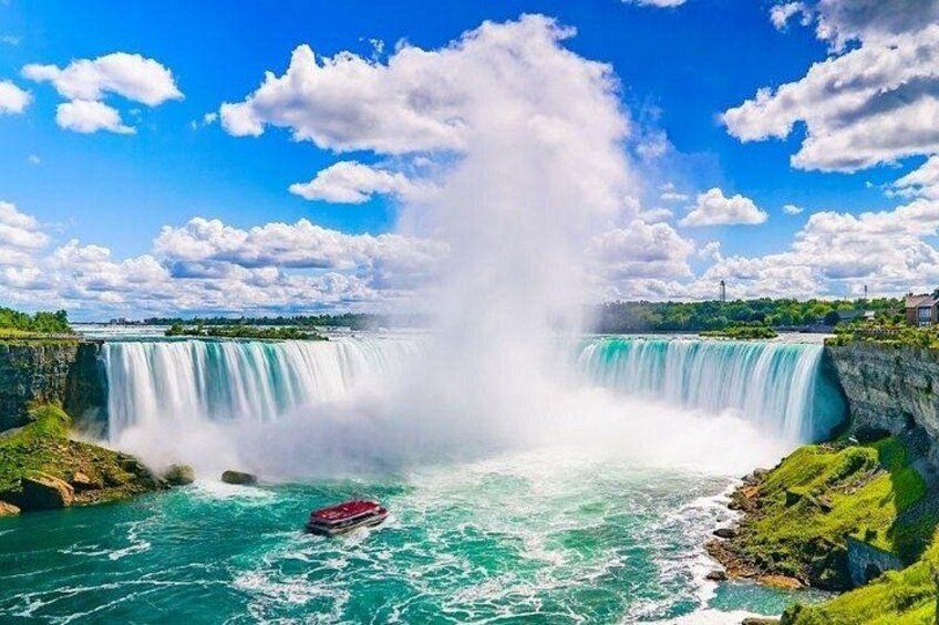 A large waterfall, a boat, and a clear blue sky. 3