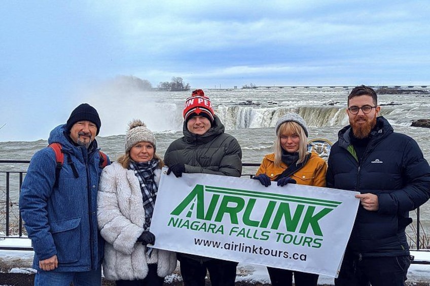 Un groupe de personnes tenant une banderole pour Airlink Niagara Falls Tours. 4