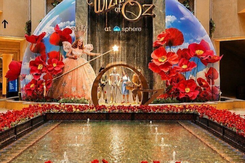 A stage with a large floral backdrop, a fountain, and a sign reading 'WIZTOZ at Sphere.' 3