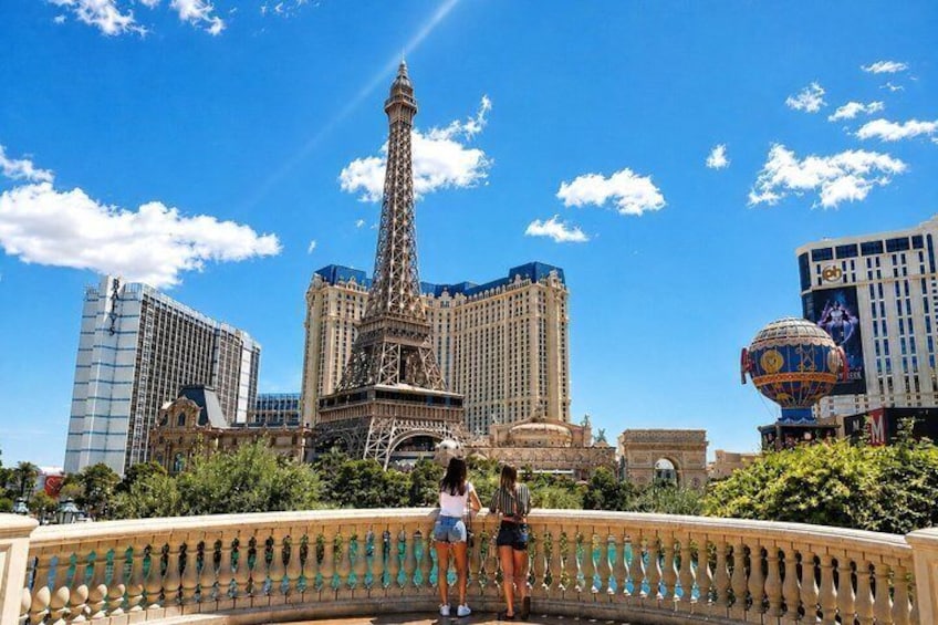 A view of the Eiffel Tower, a large hotel, and a hot air balloon in the background. 1
