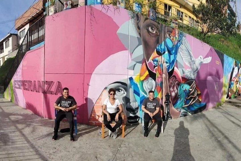 Un mural en una pared rosa con una persona sentada en un banco. 4