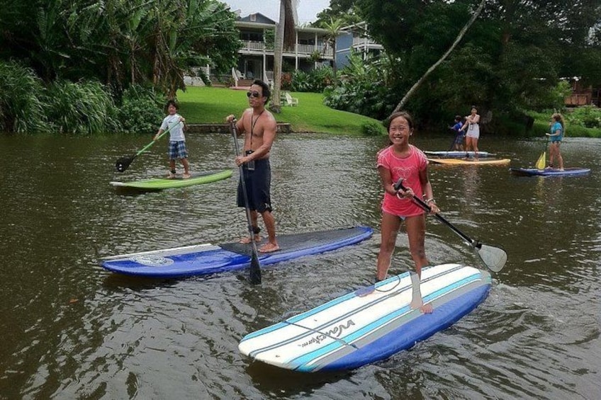 People paddleboarding on a calm river. 2