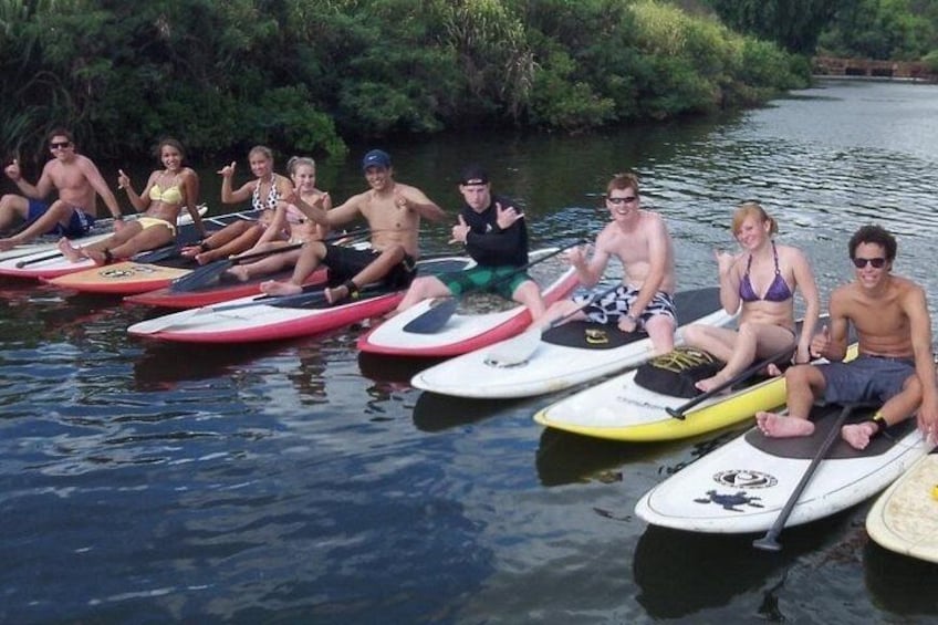 A group of people sitting on surfboards in a body of water. 3