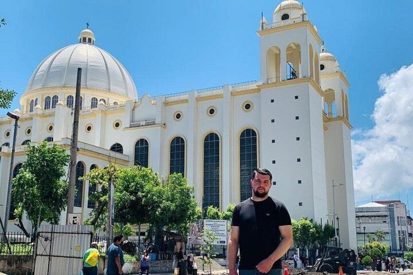 A large white church with a dome and bell tower, surrounded by trees and people. 5