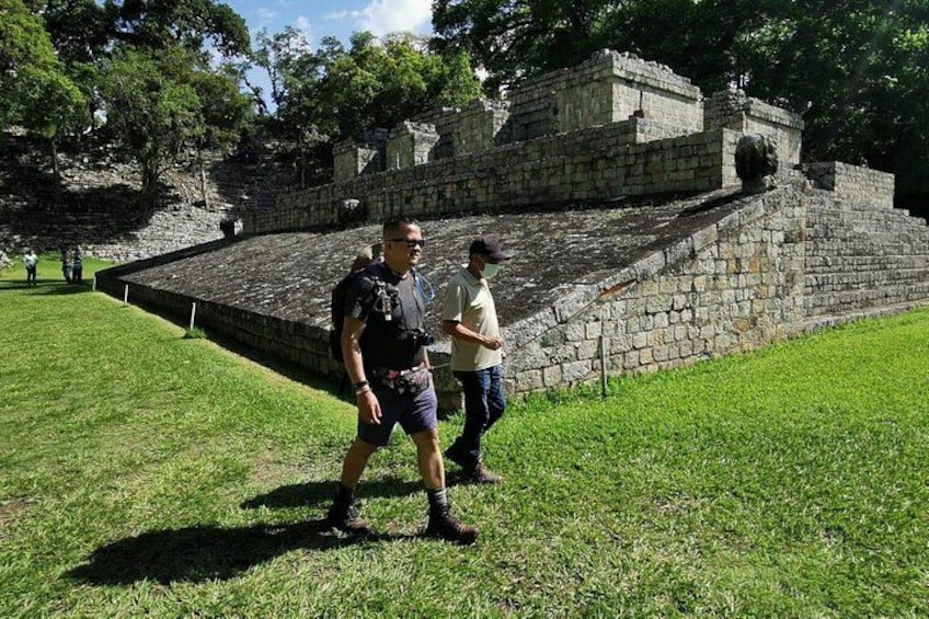 A historical stone structure with a grassy foreground and trees in the background. 5