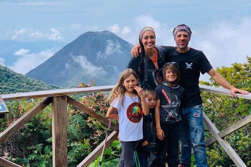 A family standing on a wooden platform with a mountain in the background. 5