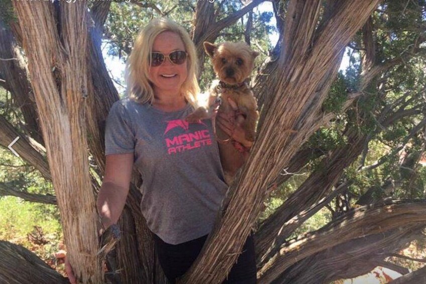 A person holding a small dog in a tree. 2