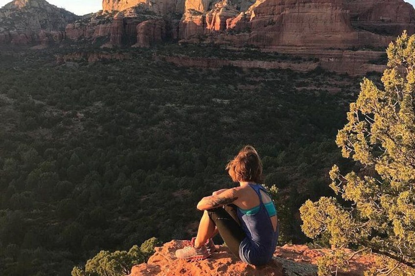 A person sitting on a rock with a mountainous landscape in the background. 1