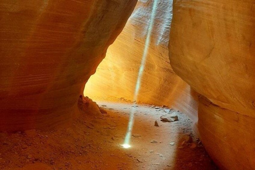 A canyon with a narrow passageway and a beam of light entering from above. 2