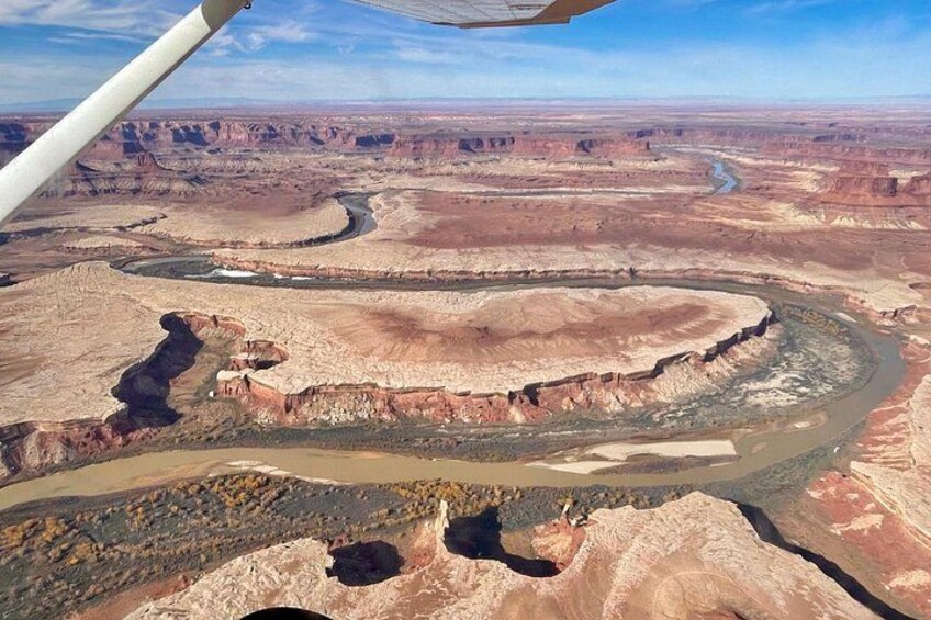 Et stort canyonlandskab med slyngende floder og barsk terræn. 2