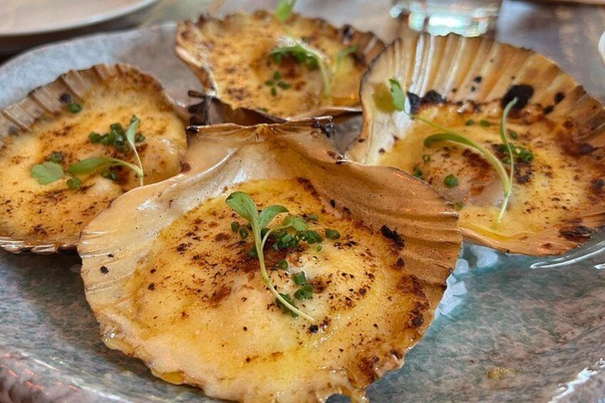 Scallops served on a plate with a garnish. 2