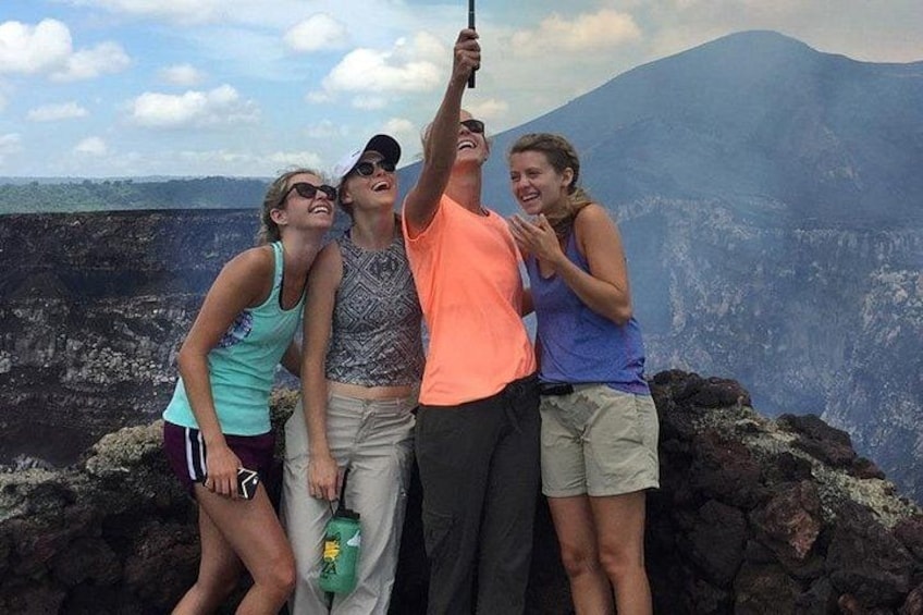 Four people taking a selfie with a volcanic landscape in the background. 4