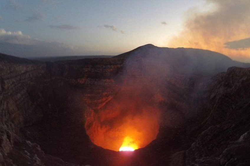 A deep crater with a glowing lava pool at its center. 2