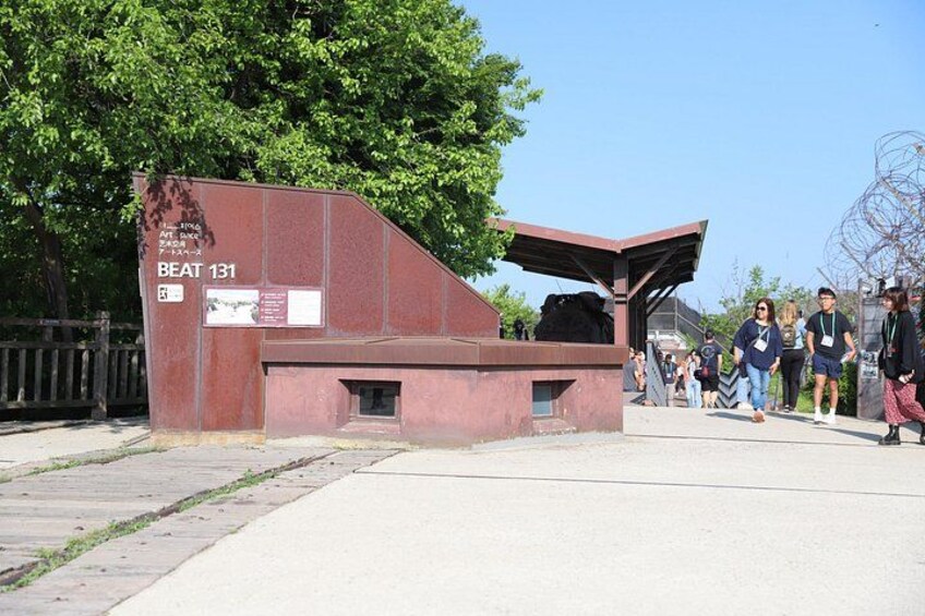 A red metal structure with a roof, labeled 'BEAT 131,' and a paved walkway with people walking. 3