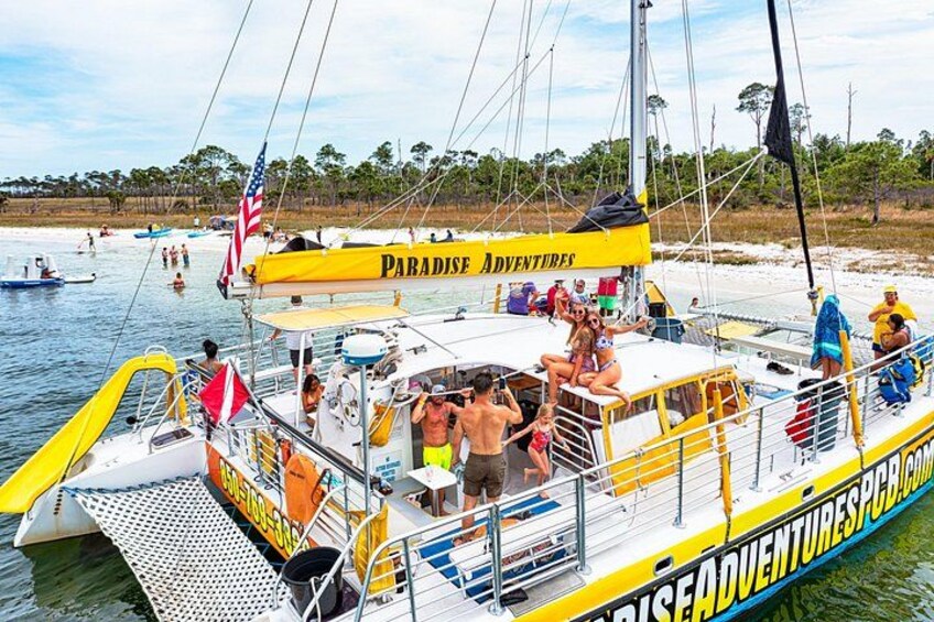 En båd, der hedder 'Paradise Adventures', med mennesker om bord, en redningskrans og et flag. 3