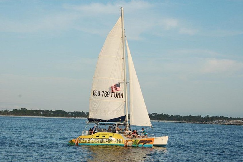 A sailboat with a white sail and a number on it, floating on water. 2
