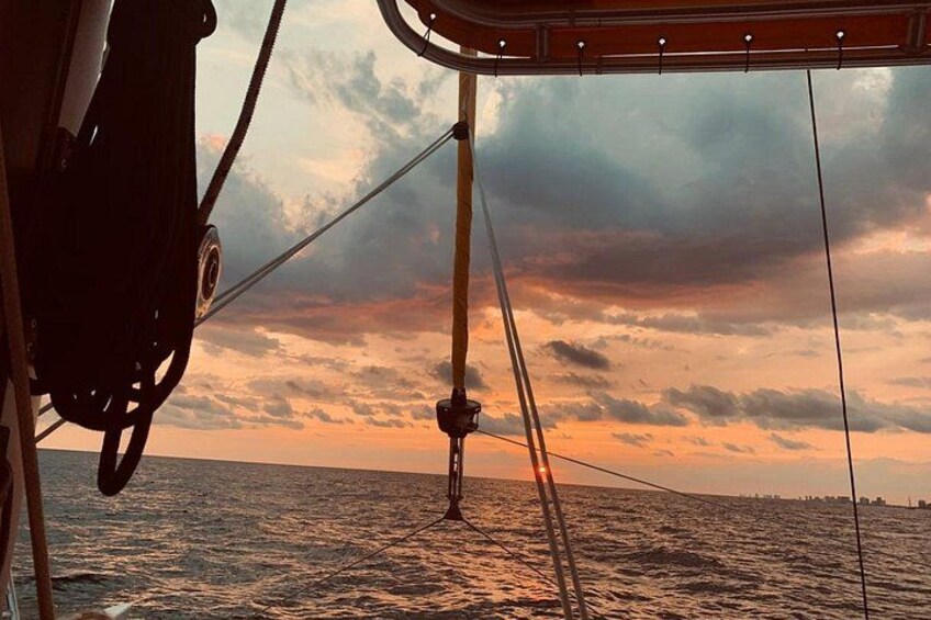 A boat with a view of the ocean and a sunset sky. 3