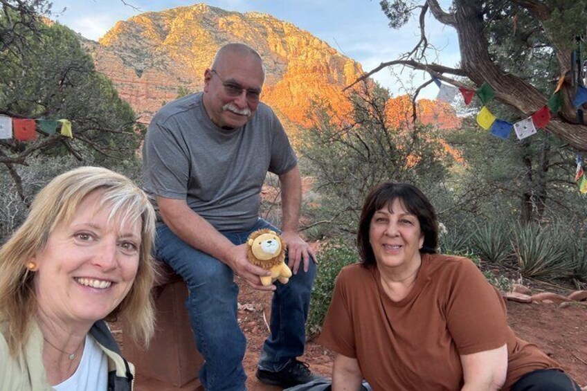 Three people in a natural setting with a mountainous background. 5