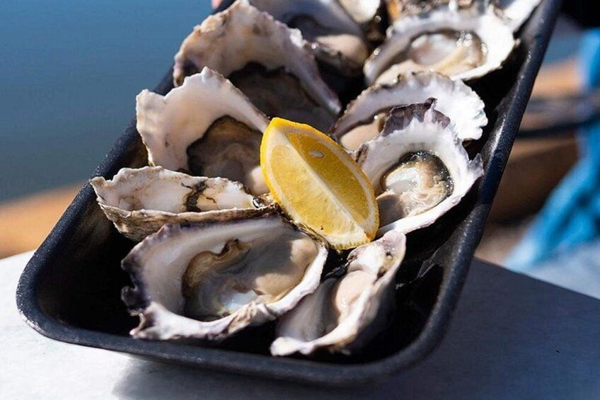 A tray of oysters with lemon slices. 4