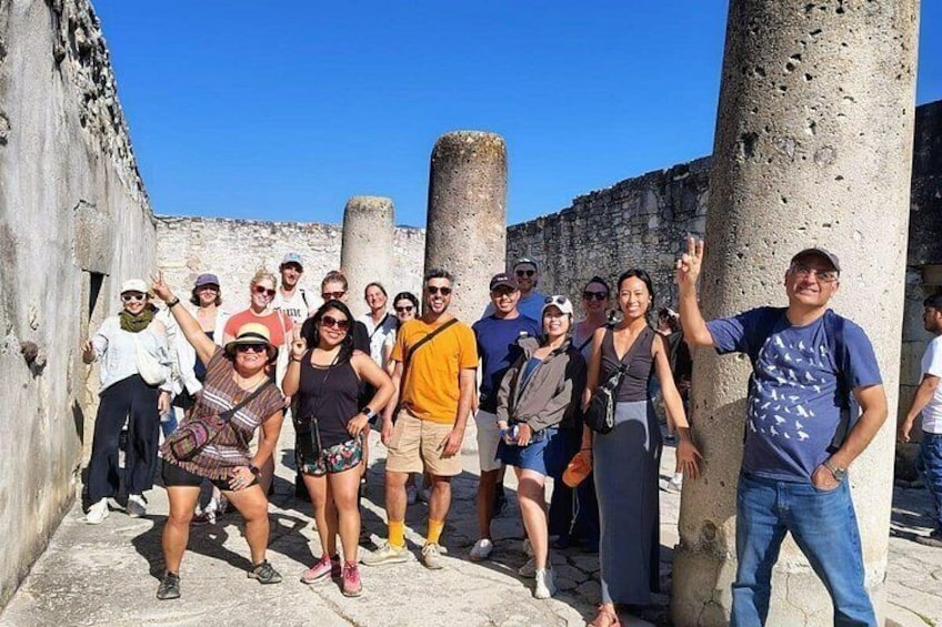 A group of people standing in front of ancient ruins with columns. 5