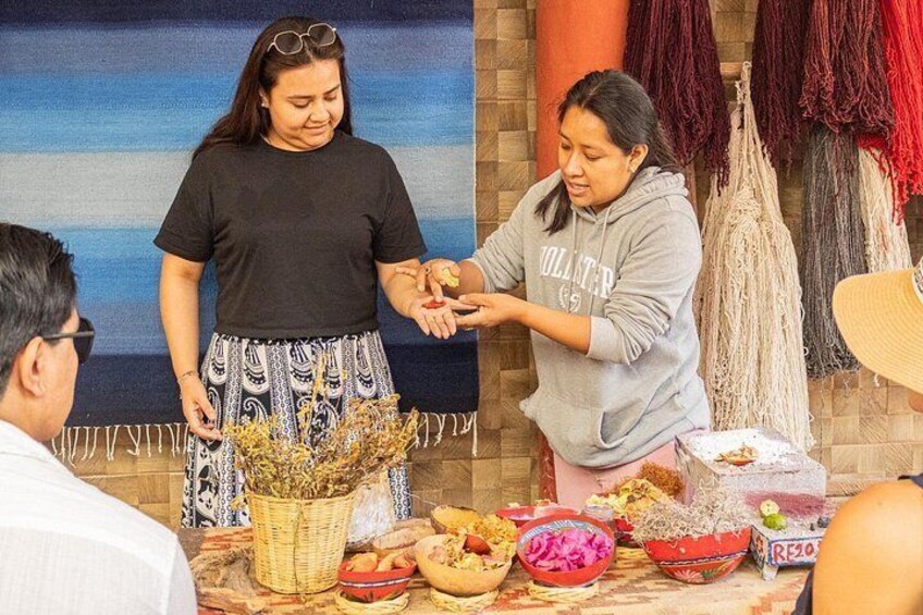 Two people exchanging items at a table with various objects and decorations. 3