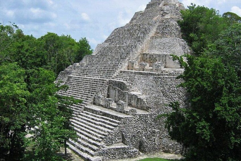 A large stone pyramid structure surrounded by lush greenery. 4