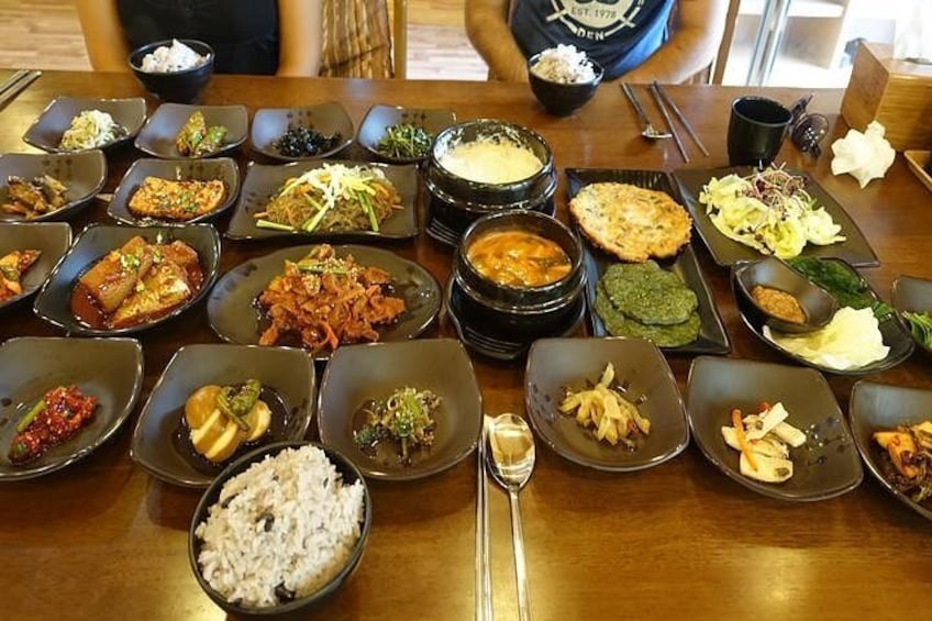 A wooden table with various dishes and bowls of food. 1