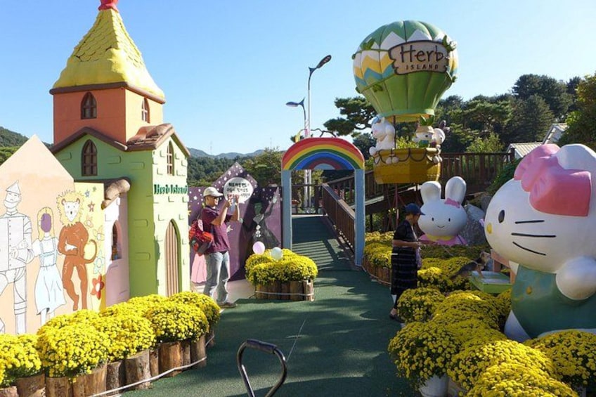 A themed park with a castle, a hot air balloon, a rainbow arch, and a large Hello Kitty statue. 2