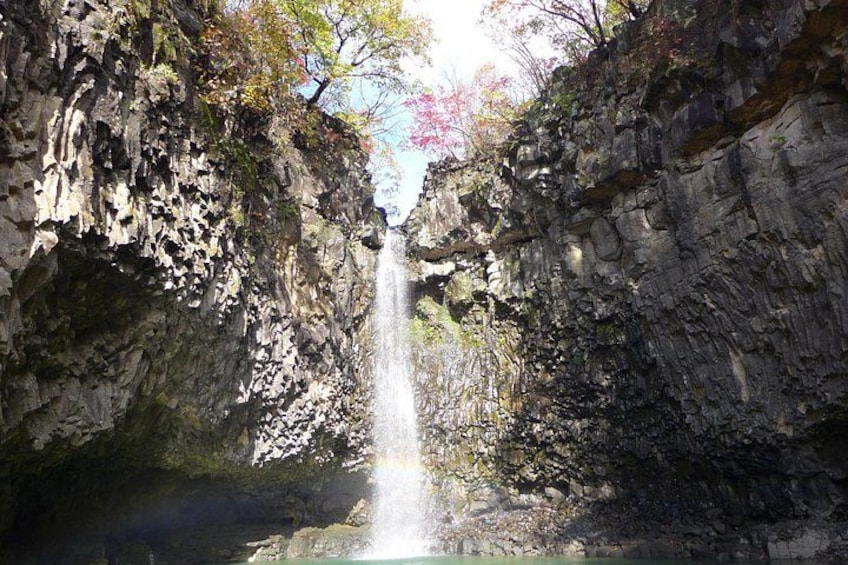 A waterfall cascading down a rocky cliff into a pool. 4