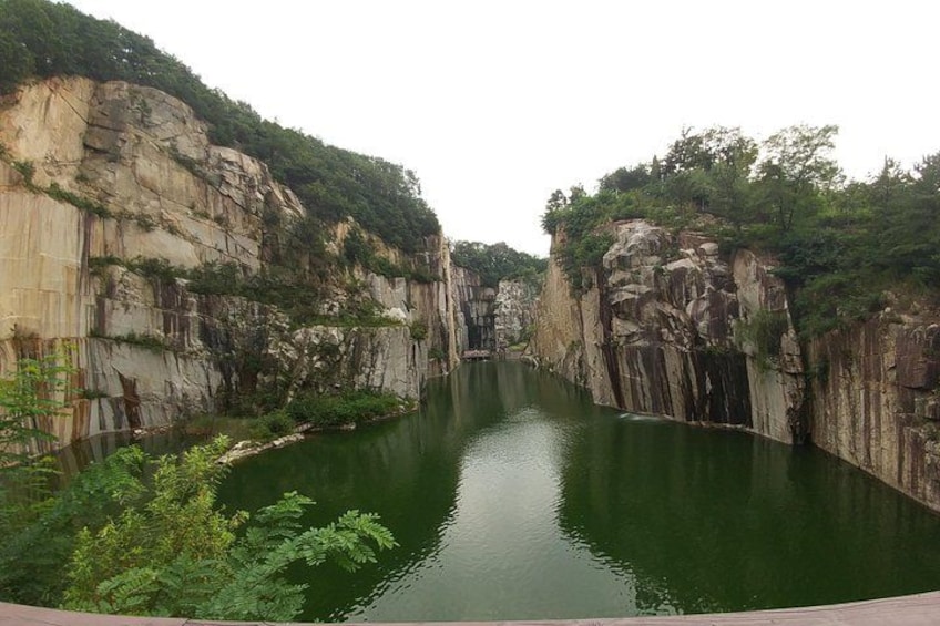 A river canyon with steep rock walls and dense greenery along the banks. 5