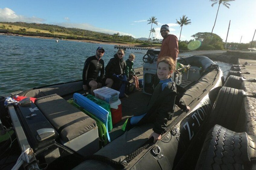 A boat with people on board, a shoreline with palm trees, and calm water. 3