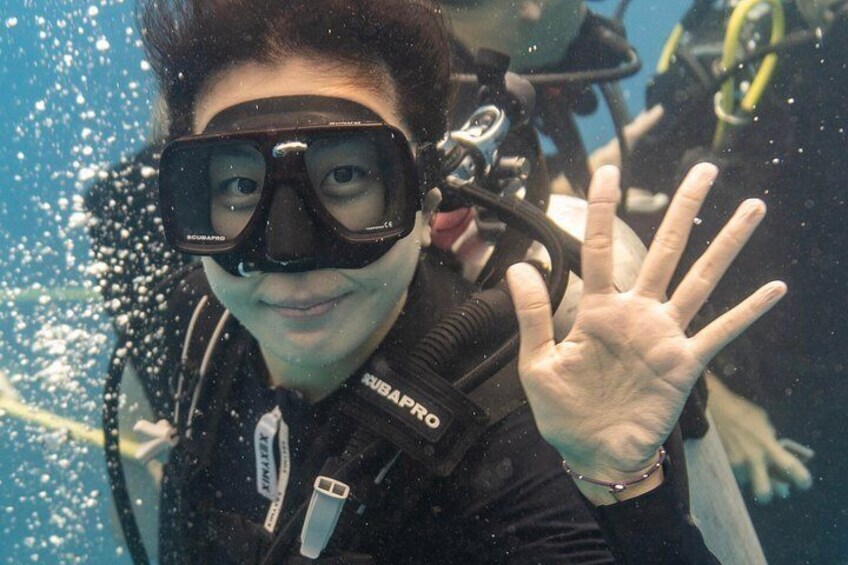 En person under vattnet, iförd dykmask och snorkel, med bubblor runt omkring. 3