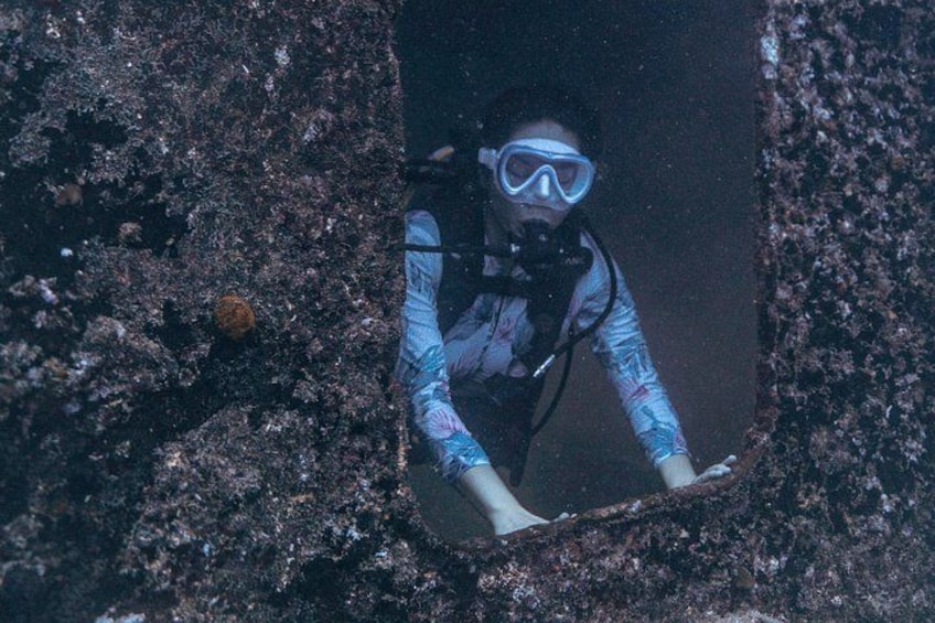 Un subacqueo in una grotta con pareti rocciose e una piccola apertura. 2