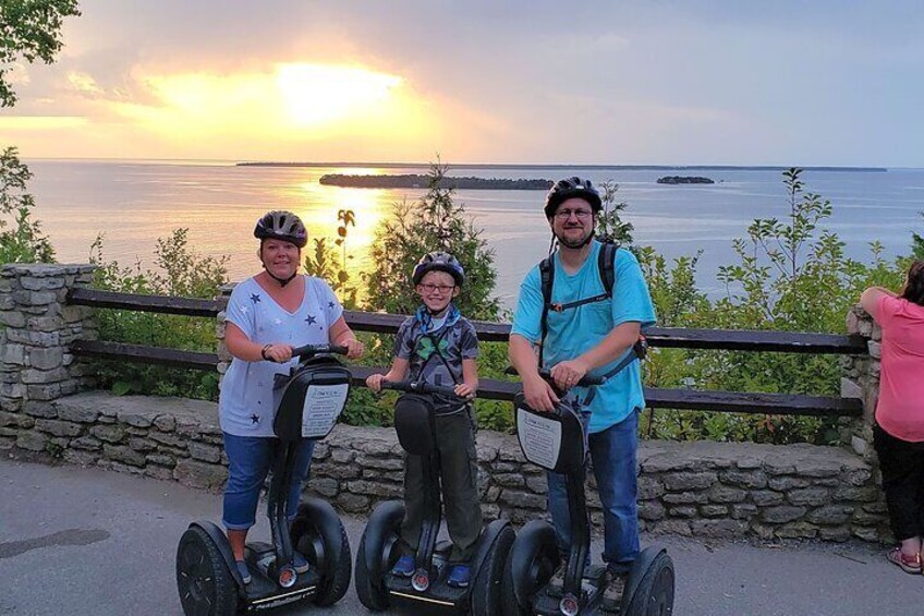 Three people on segways by a waterfront at sunset. 2