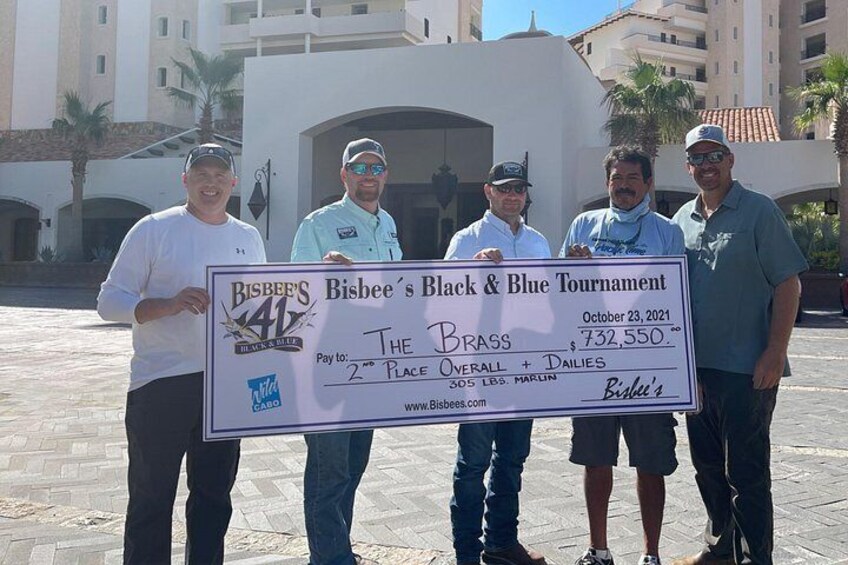Cuatro personas sostienen un cheque grande por $732,550 en el Torneo Black & Blue de Bisbee. 5