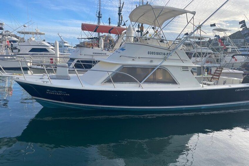 Un barco amarrado en un puerto deportivo, con otros barcos al fondo. 2