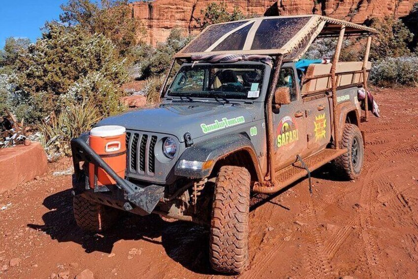 A rugged off-road vehicle with a safari theme parked on a dirt road. 5