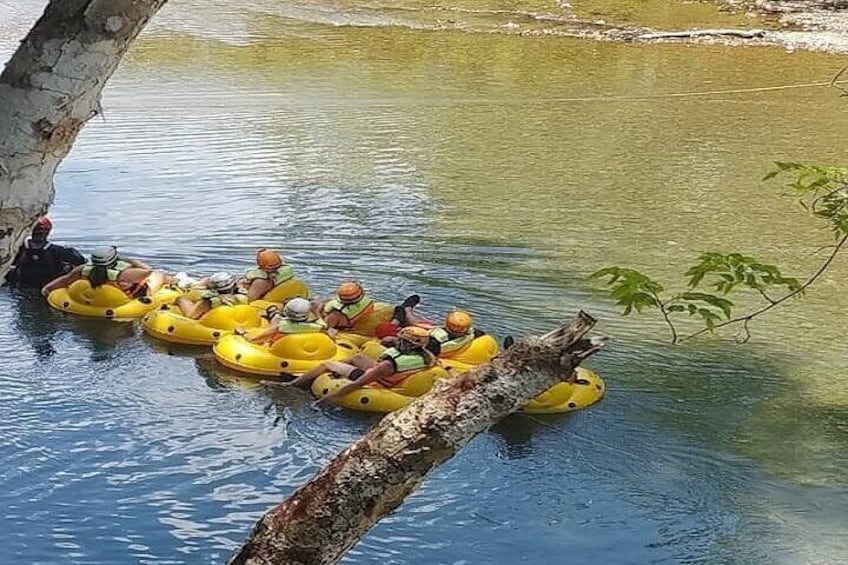 Personas en balsas hinchables amarillas sobre un cuerpo de agua tranquilo. 4