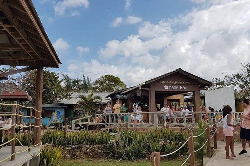 Un restaurant appelé « No Name Bar », doté d’une structure en bois, entouré d’une barrière faite de cordes et agrémenté d’un jardin planté. 2