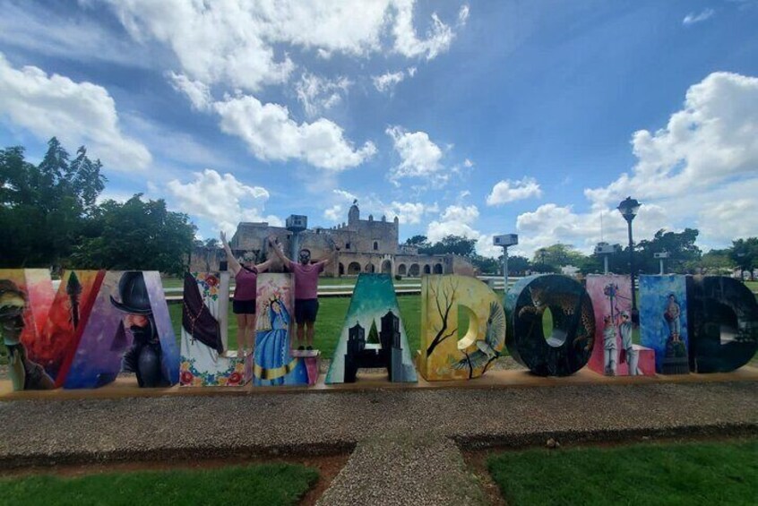 Un murale colorato con lettere dipinte che compongono una parola, un castello sullo sfondo e un cielo azzurro intenso. 4