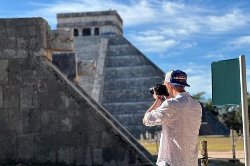 Eine Person fotografiert eine große Pyramidenstruktur. 2